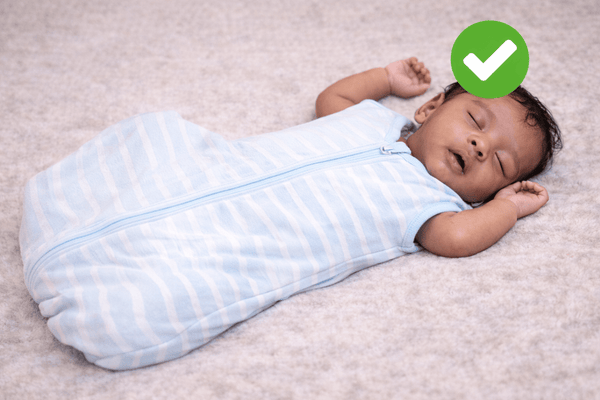 Baby sleeping on their back in a sleeveless wearable blanket with arms free, the safer alternative to a loose blanket