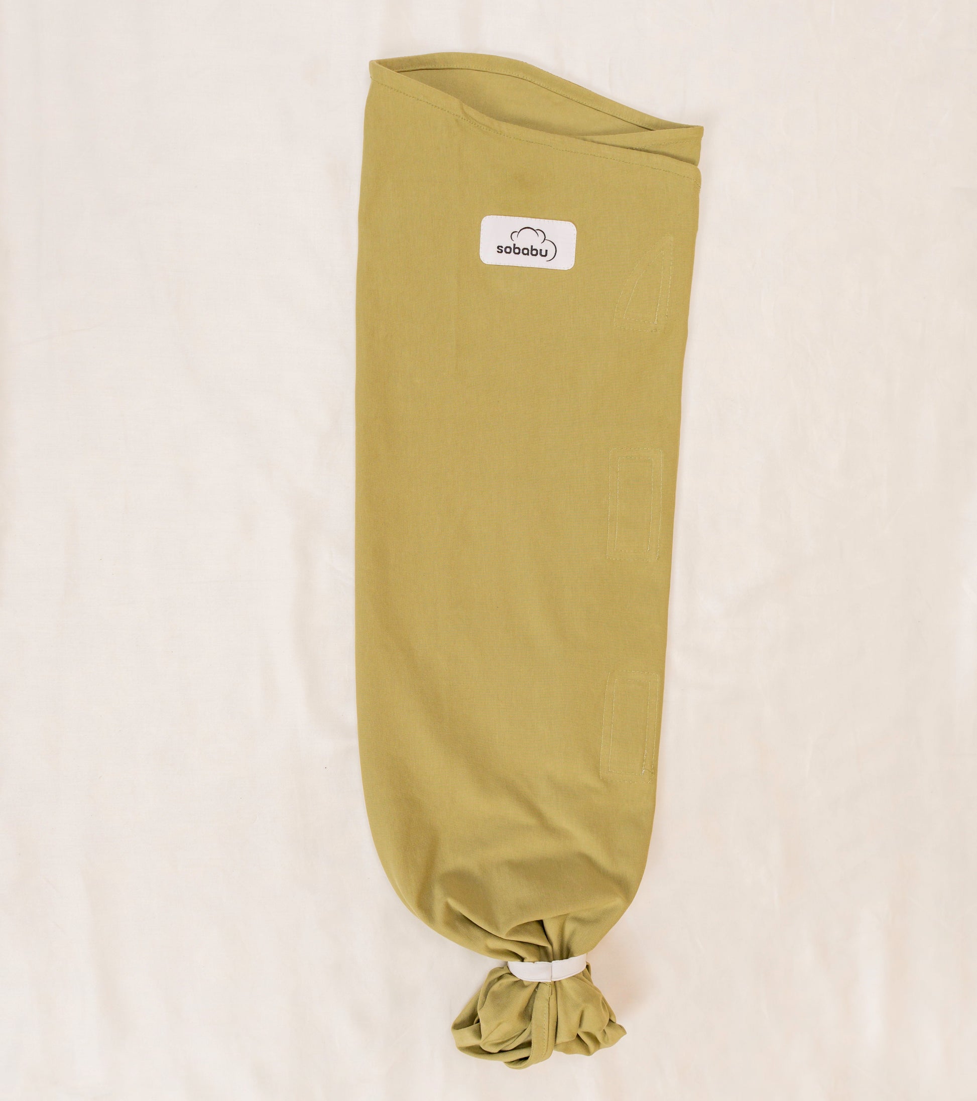 Green baby swaddle with a visible brand logo on a beige background