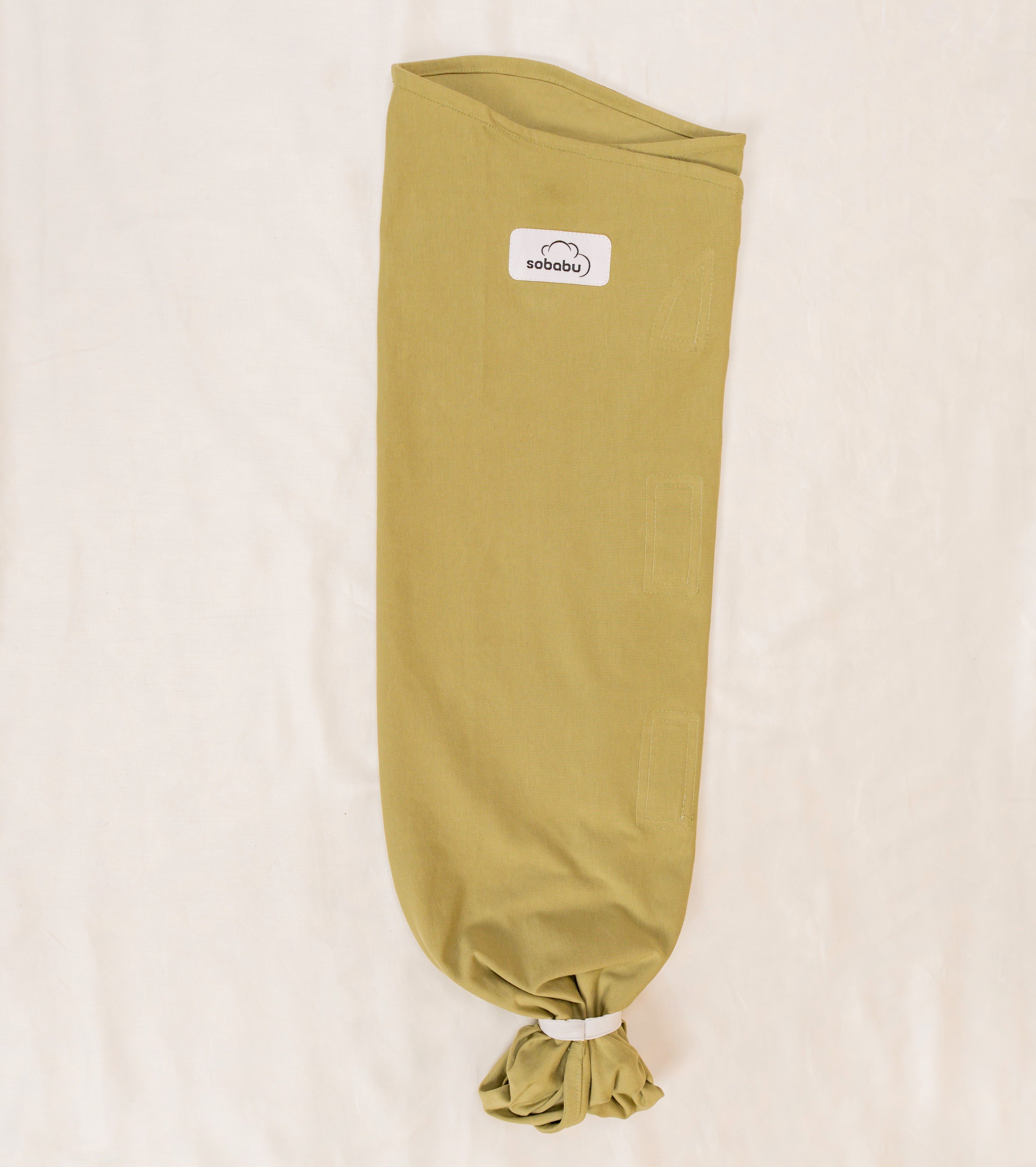 Green baby swaddle with a visible brand logo on a beige background