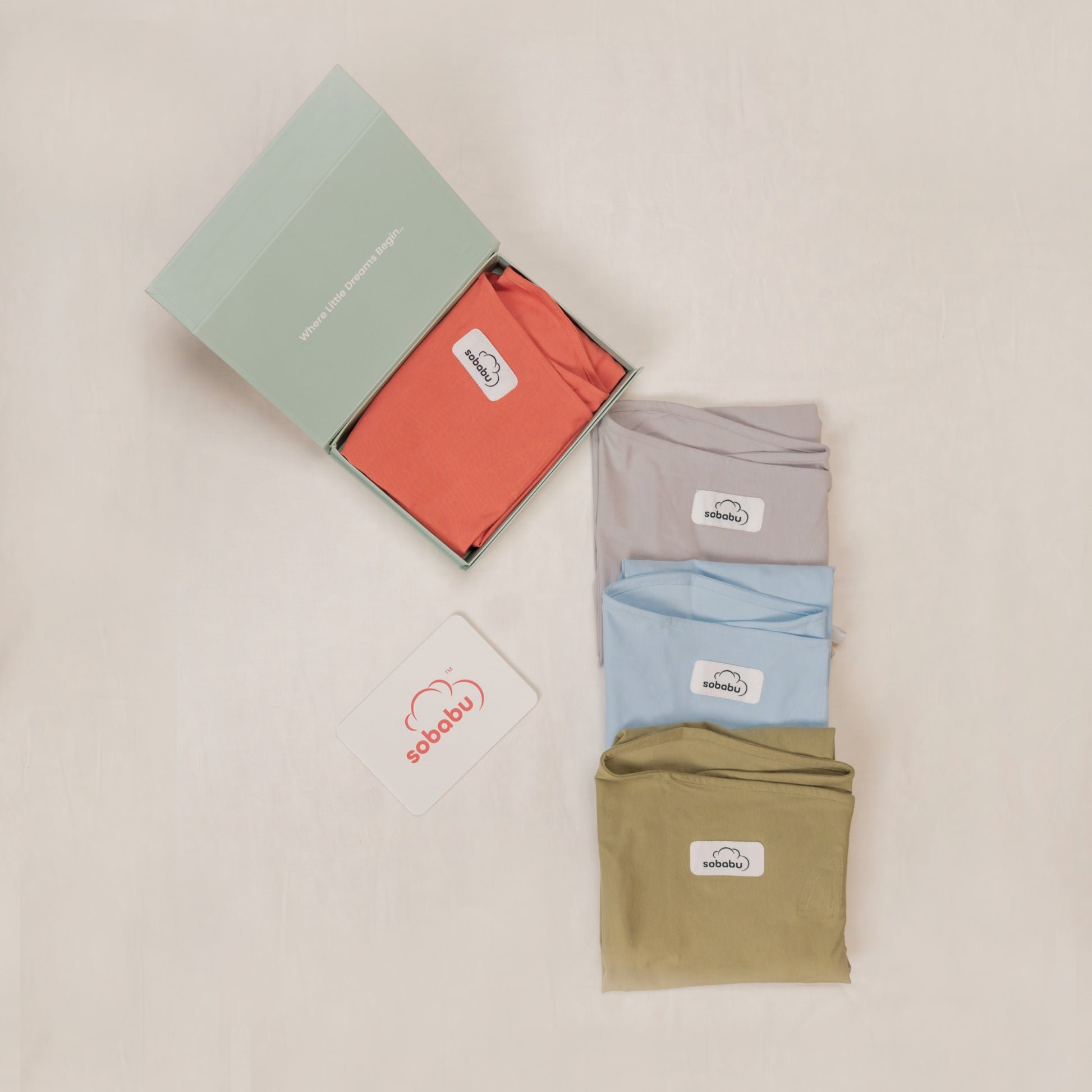 Four folded shirts in red, gray, blue, and green with a visible brand logo on a beige background.