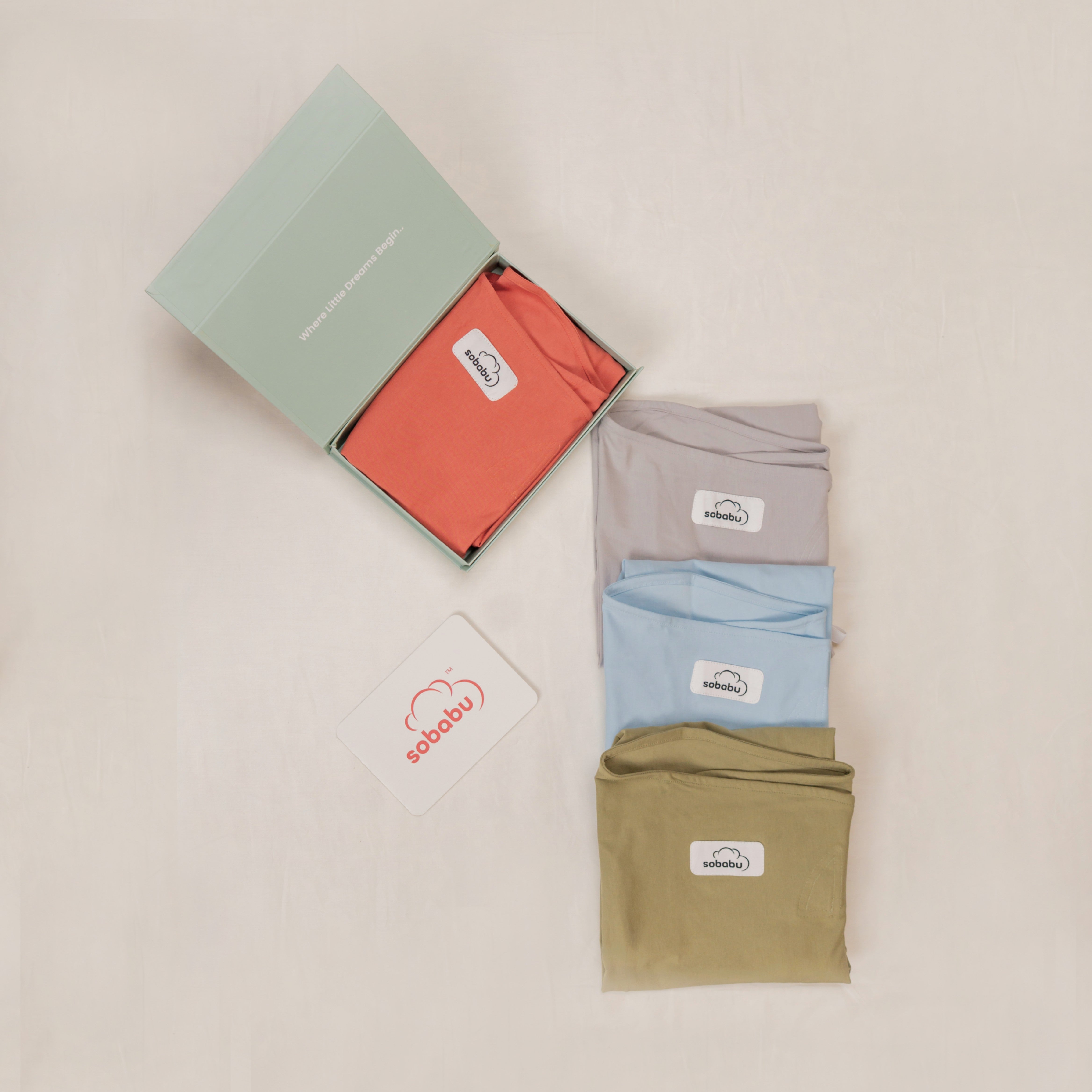 Four folded shirts in red, gray, blue, and green with a visible brand logo on a beige background.