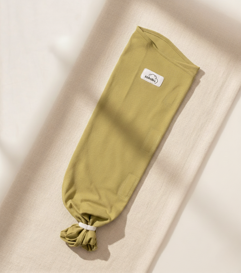 Meadow Hush Green swaddle with a brand label on a beige background
